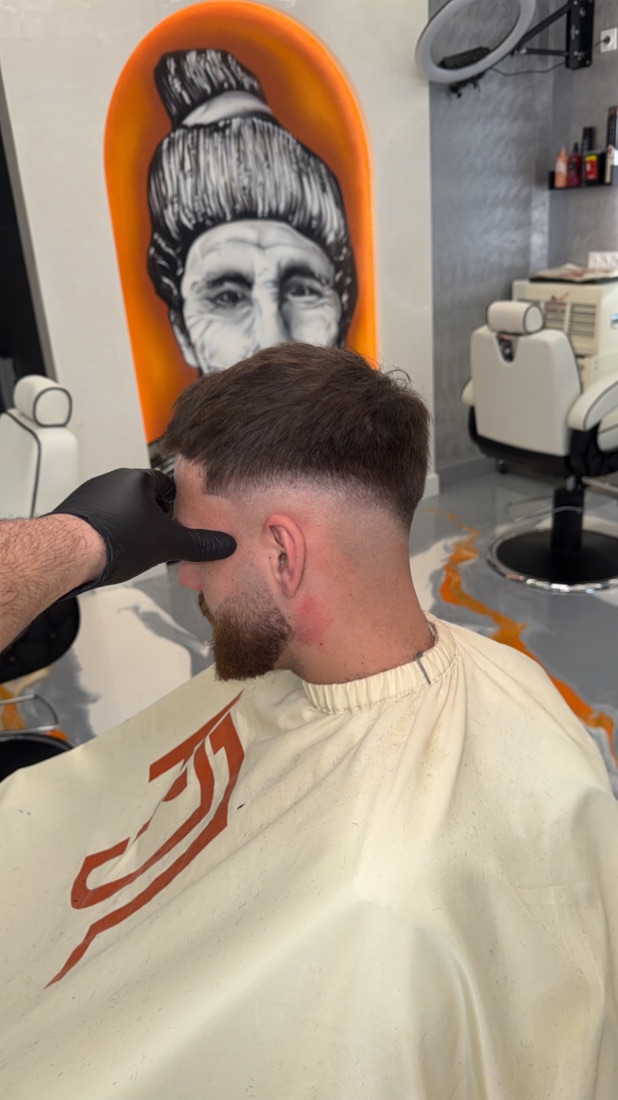 Vue arrière d'une coupe en cours avec tondeuse — Rijal Barber Club